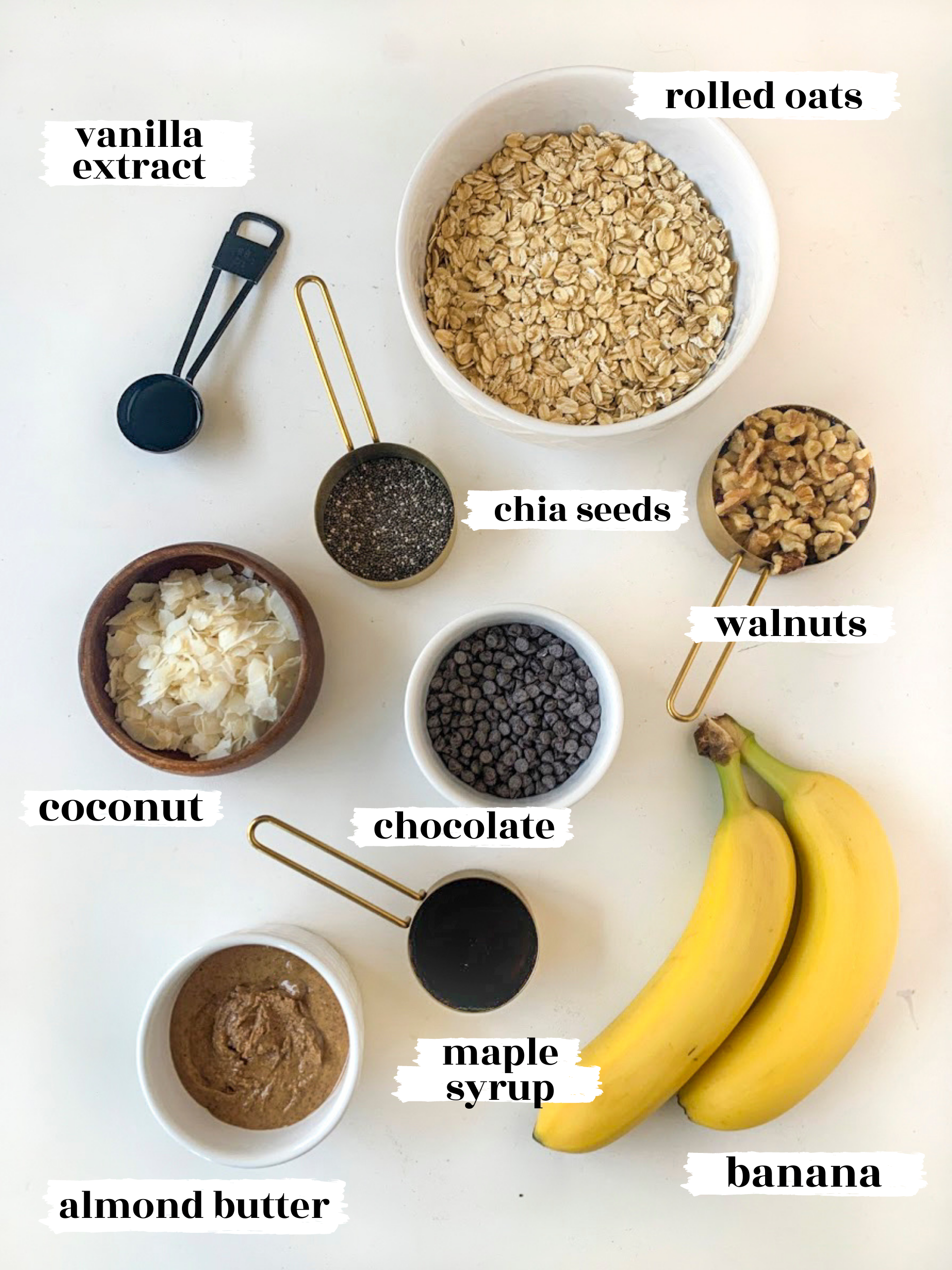 Ingredients of baked oatmeal, including oats, almond butter, banana, walnuts, chocolate chips, coconut, chia seeds and vanilla extract