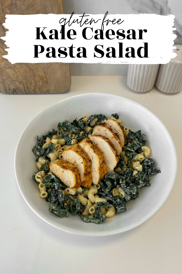 Bowl of kale caesar pasta salad with chicken on top.